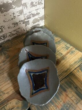 Studio pottery plates, featuring an organic, wavy rim and a multi-glaze design